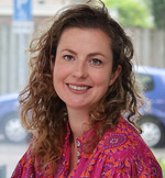 Een vrouw die bij camera glimlacht