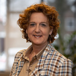 Een vrouw die bij camera glimlacht