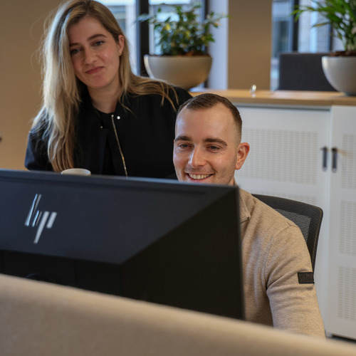 Een man en een vrouw die een computerscherm bekijken