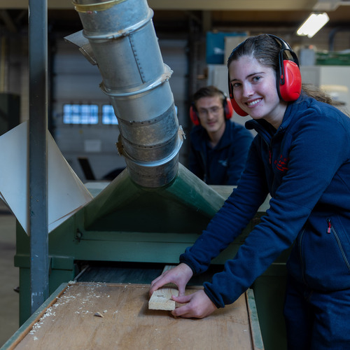 Vrouw en man en zaagmachine