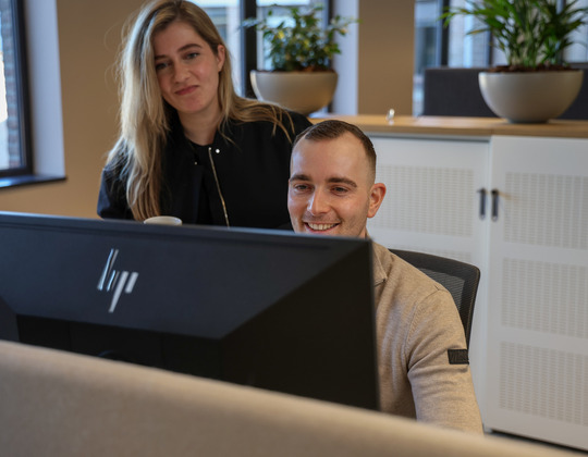 Een man en een vrouw die een computerscherm bekijken