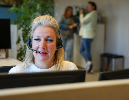 Een vrouw die een headset draagt en op een headset praat