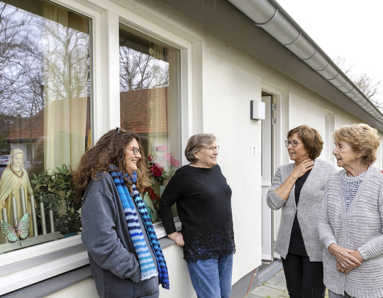 Een groep vrouwen die zich buiten een gebouw bevinden