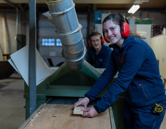 Vrouw en man en zaagmachine
