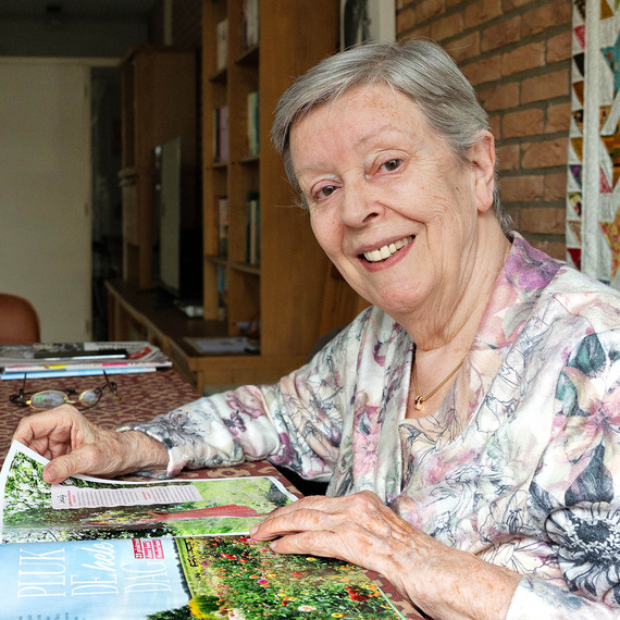 Vrouw leest magazine aan tafel