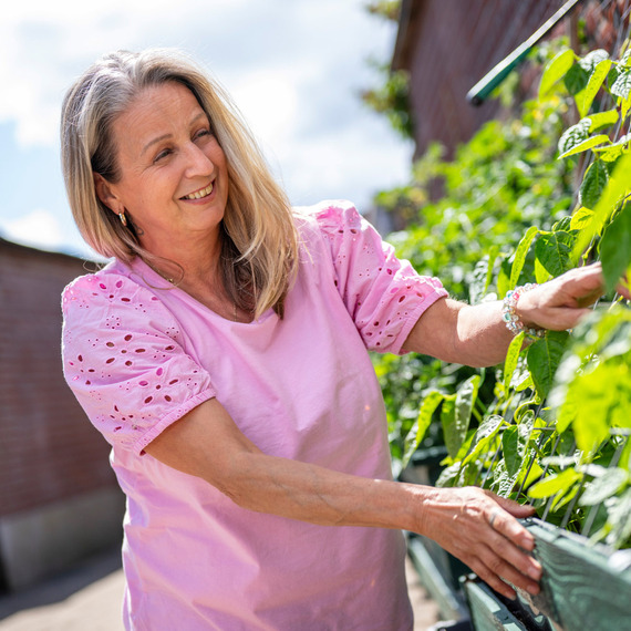 Een vrouw die een plant aanraakt