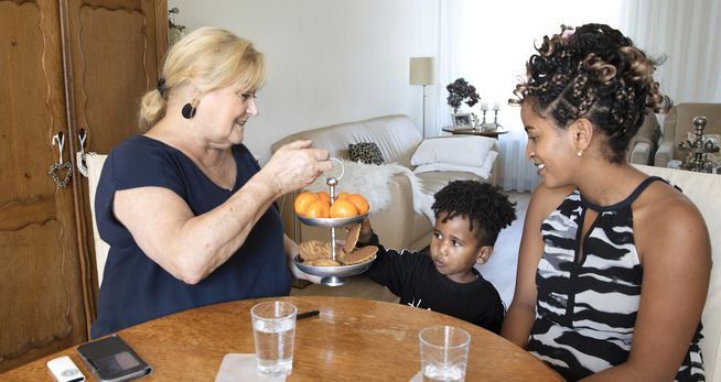 Een vrouw die een dienblad met sinaasappelen vasthoudt