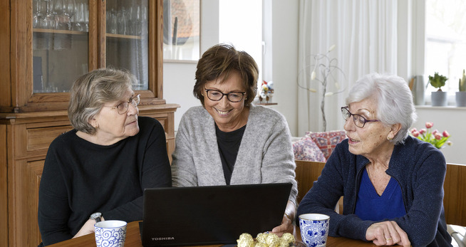 Natuurlijk Samen Een groep vrouwen die een laptop bekijken