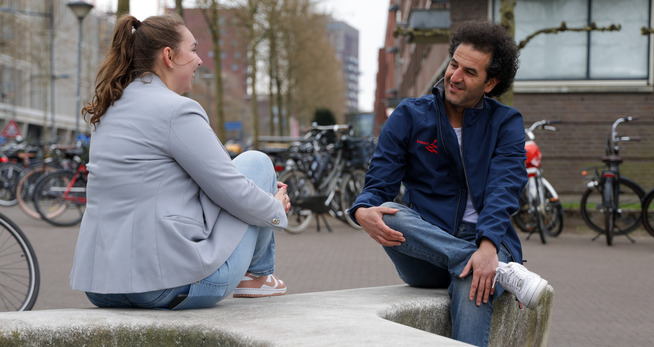 Een man en een vrouw zittend op een stenen richel