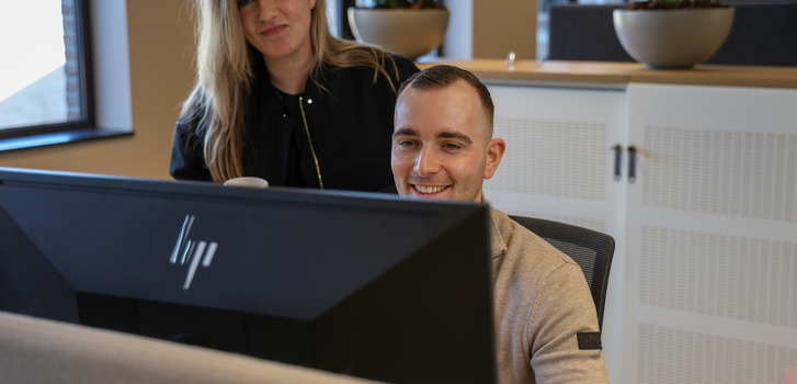 Een man en een vrouw die een computerscherm bekijken