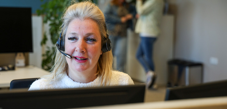 Een vrouw die een headset draagt en op een headset praat