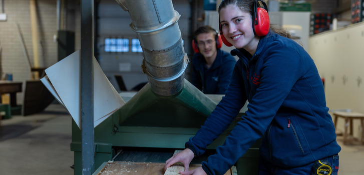 Vrouw en man en zaagmachine
