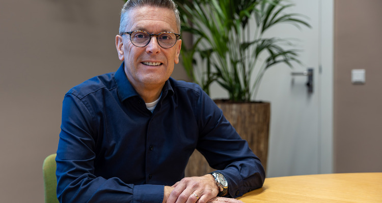 man met bril zittend aan tafel