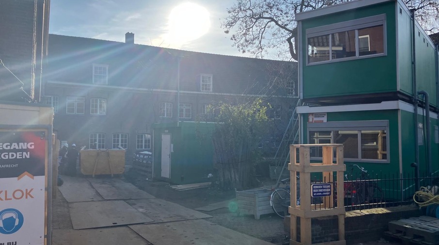 een gebouw met een groene muur en een hek