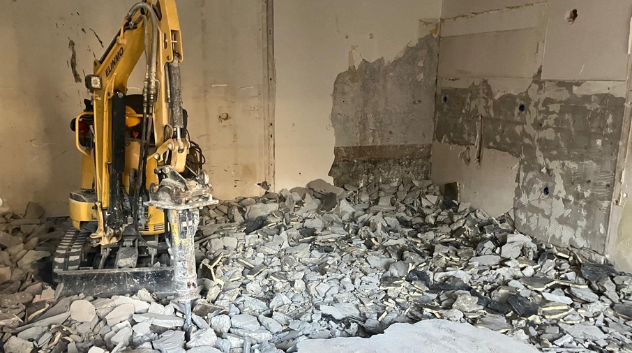 een bouwmachine in een kamer met puin