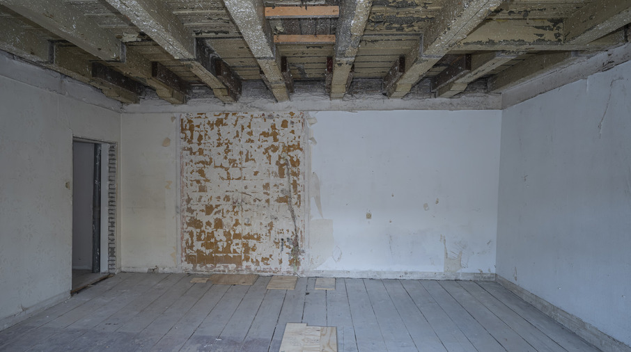 een kamer met houten balken en een muur