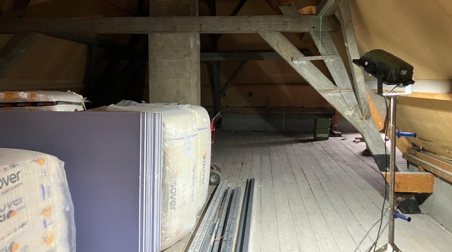 een kamer met een houten vloer en een grote stapel wit materiaal