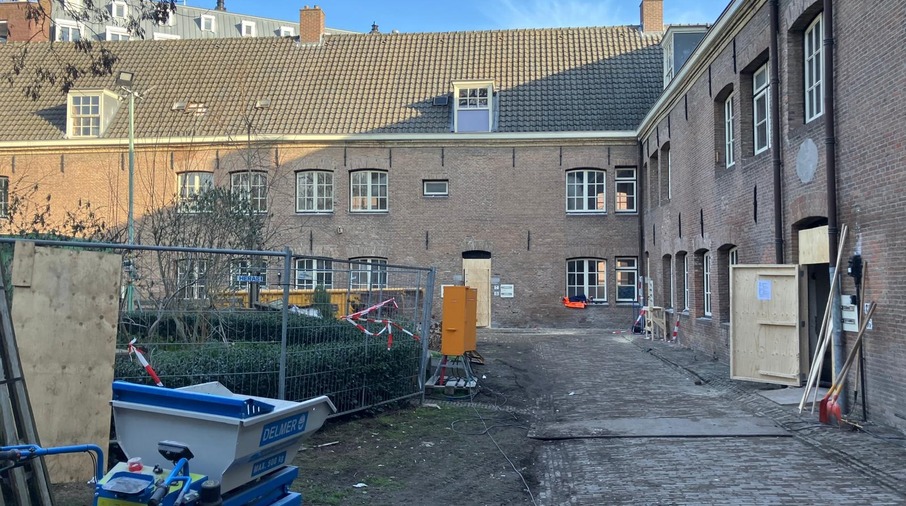 een gebouw met een hek en een kar