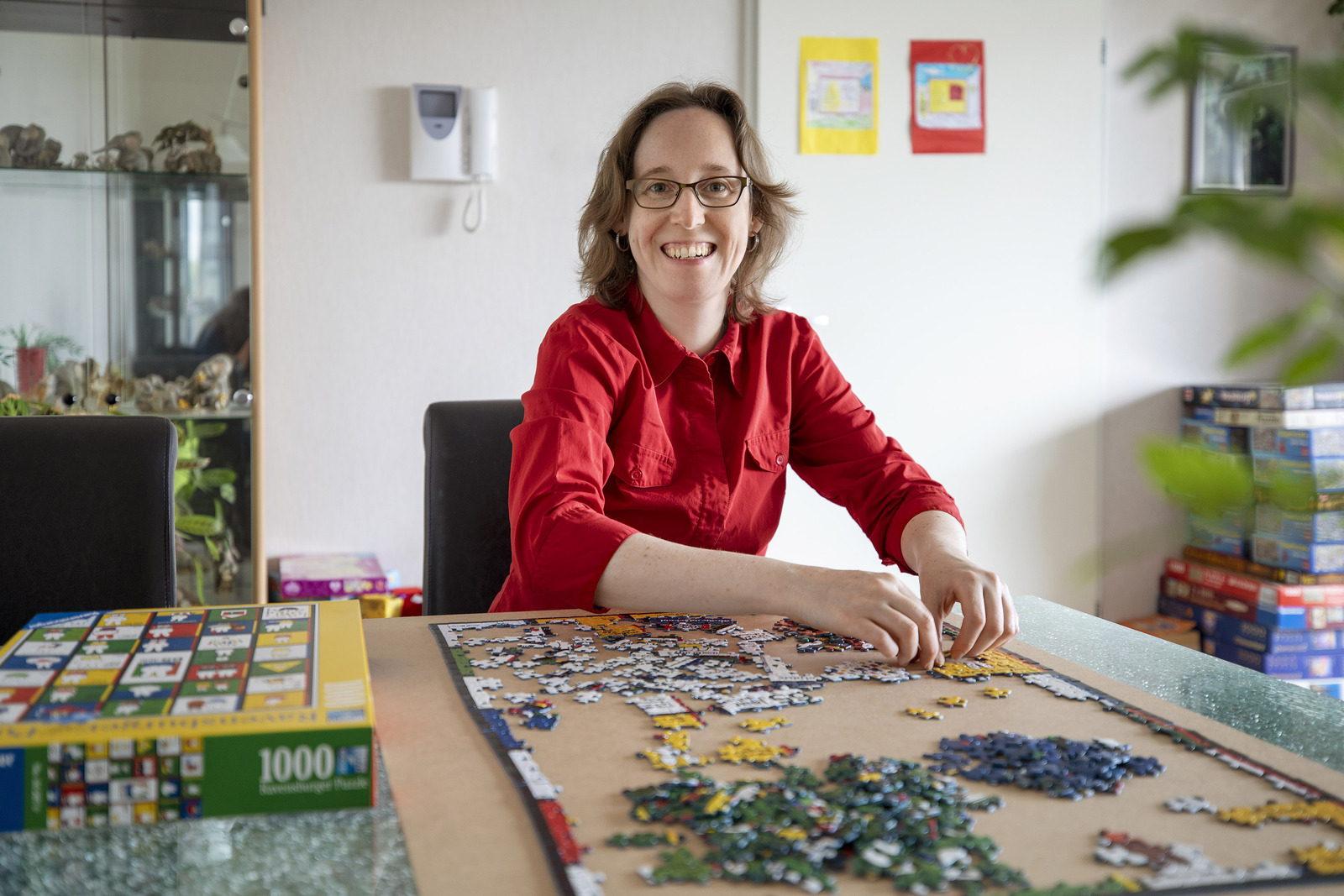 Een vrouw zittend aan een tafel met een raadsel