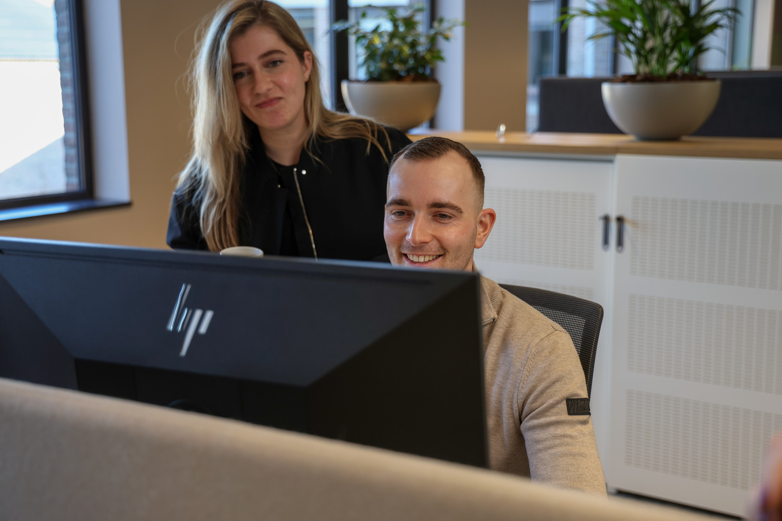 Een man en een vrouw die een computerscherm bekijken