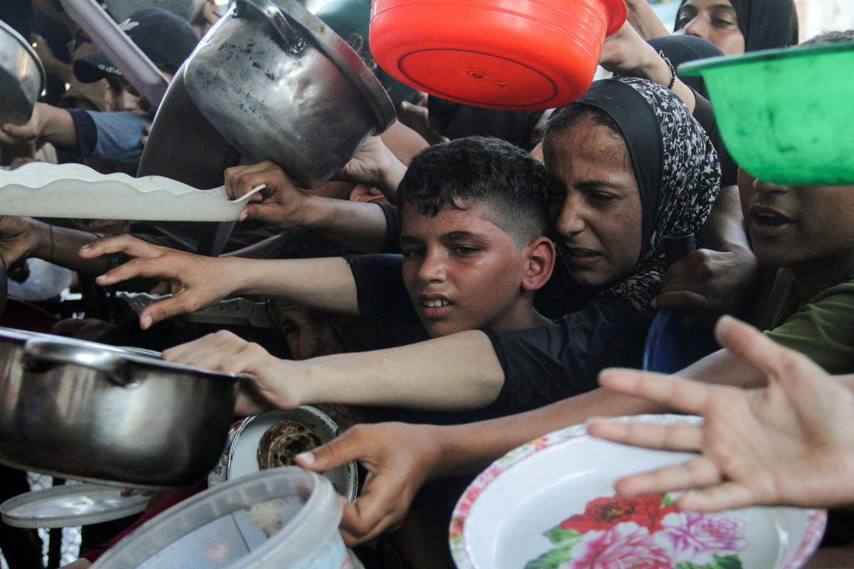 Op de foto staat een moeder met kind uit Gaza die voedselhulp vragen