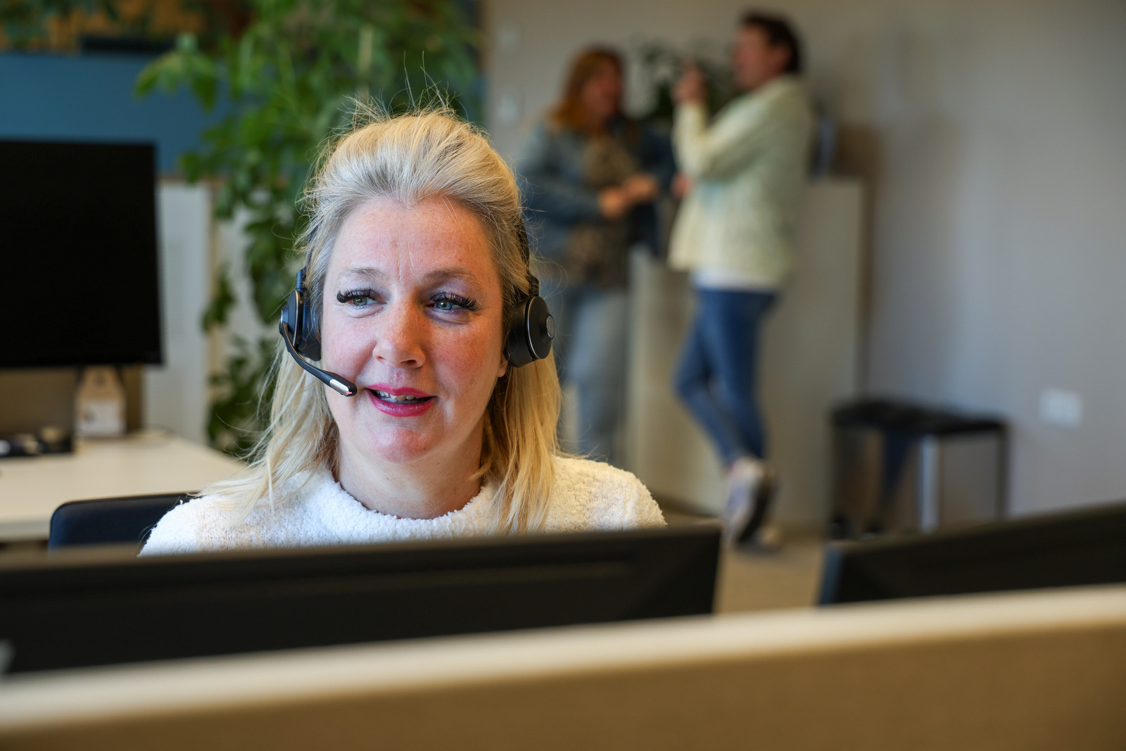 Een vrouw die een headset draagt en op een headset praat