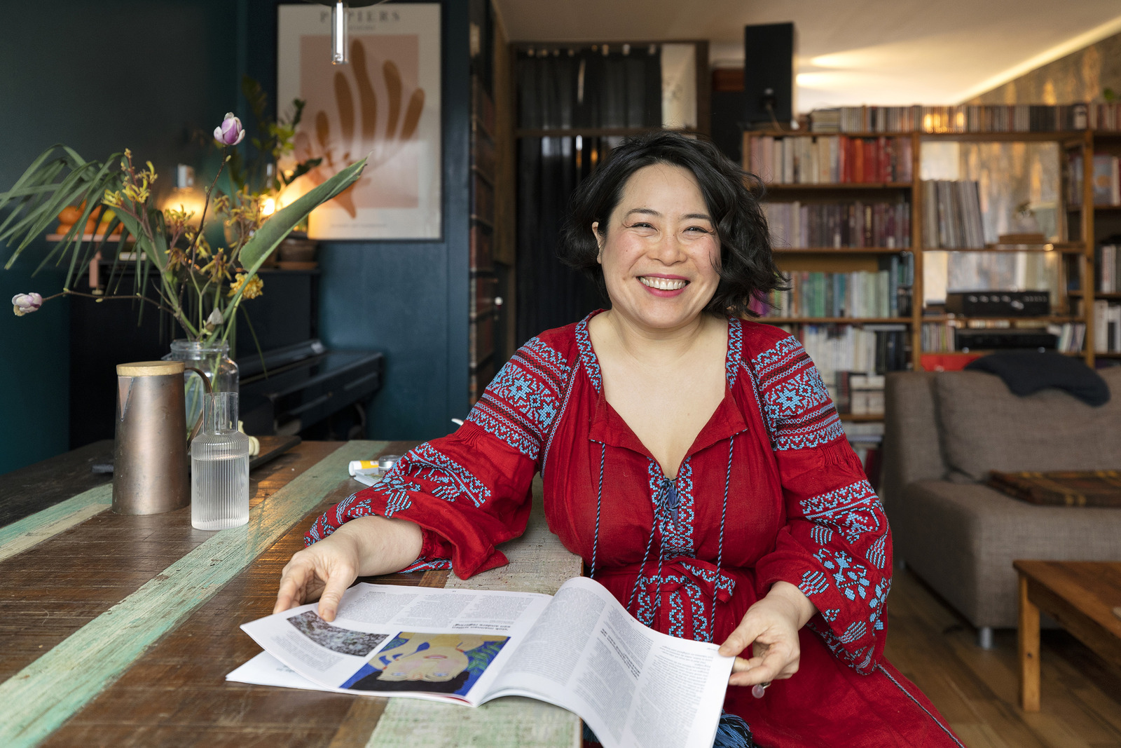 Een vrouw zittend aan een tafel met een boek