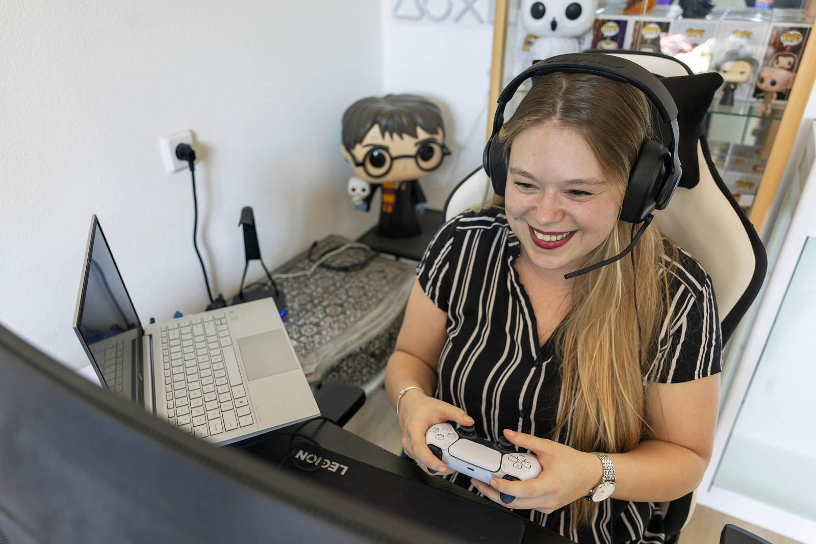 Jonge vrouw met hoofdtelefoon en spelcomputer