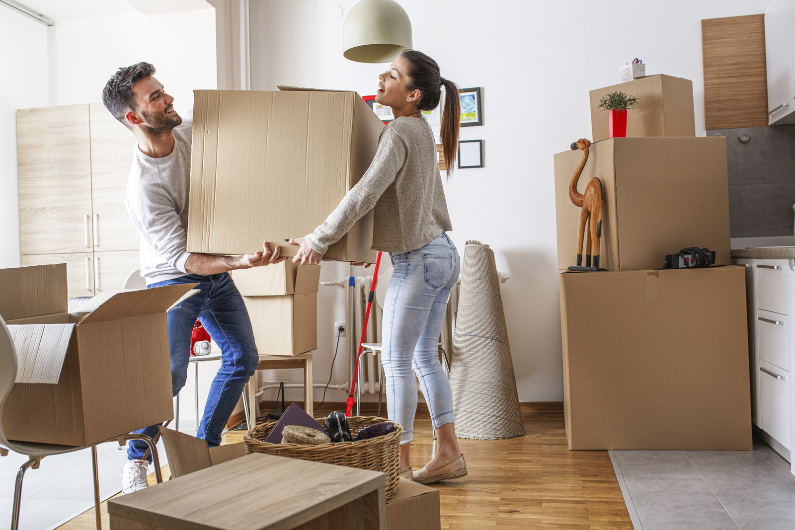 Man en vrouw dragen een kartonnen verhuisdoos