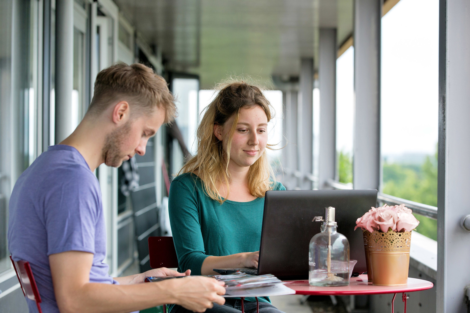 Een man en een vrouw zitten aan een tafel met een laptop