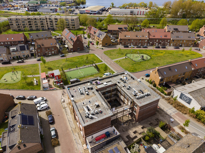 Een luchtfoto van een stad met een parkeerplaats en een rivier