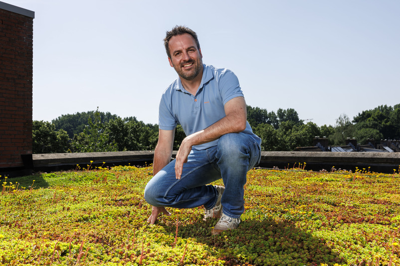 Man op een dak van sedum