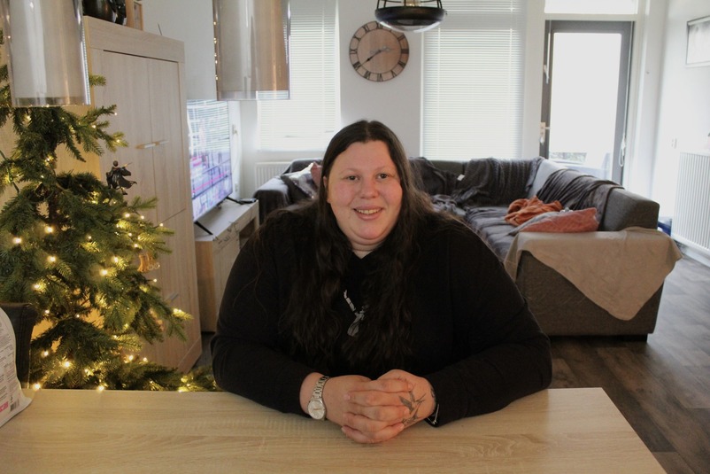 Een vrouw die aan een tafel zit