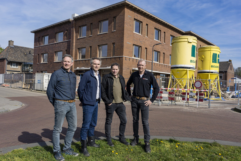 Een groep mannen die voor een gebouw staat