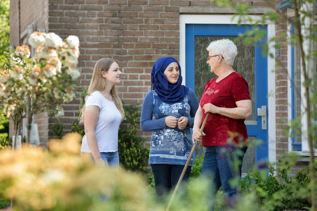 Een groep vrouwen die zich buiten een huis bevinden